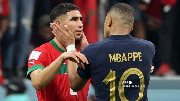Penyerang Prancis #10 Kylian Mbappe menghibur bek Maroko #02 Achraf Hakimi pada akhir pertandingan sepak bola semifinal Piala Dunia Qatar 2022 antara Prancis dan Maroko di Stadion Al-Bayt di Al Khor, utara Doha pada 14 Desember 2022.