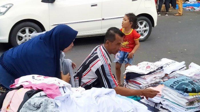 Pedagang kaos, Latif, saat melayani pembeli di Pasar Kaget, kawasan Jalan Taman Cut Mutiah, Jakarta Pusat, Jumat (21/6/2019).