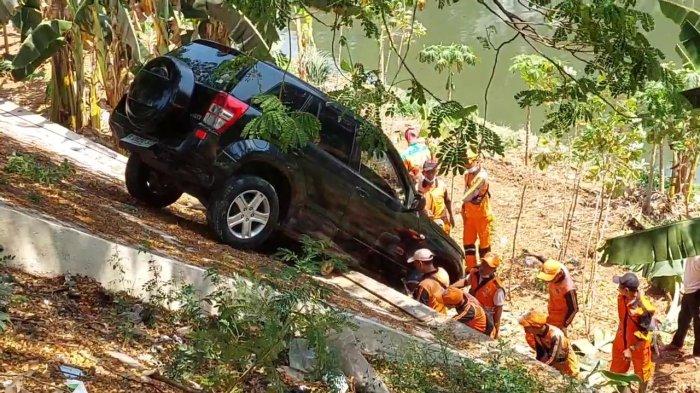 Proses evakuasi unit mobil Suzuki Grand Vitara yang terperosok ke tepi aliran Kanal Banjir Timur, Duren Sawit, Jakarta Timur, Selasa (12/9/2023)