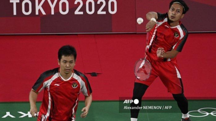 Pebulutangkis Indonesia Mohammad Ahsan (atas) melakukan pukulan di sebelah Hendra Setiawan dari Indonesia dalam pertandingan penyisihan grup bulu tangkis ganda putra melawan Aaron Chia dari Malaysia dan Soh Wooi Yik dari Malaysia selama Olimpiade Tokyo 2020 di Musashino Forest Sports Plaza di Tokyo pada 26 Juli 2021 .