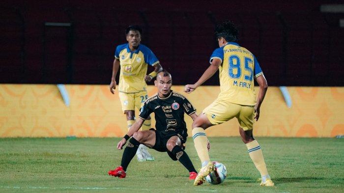 Winger Persija Jakarta, Riko Simanjuntak berusaha menjaga pemain Barito Putera di Liga 1.