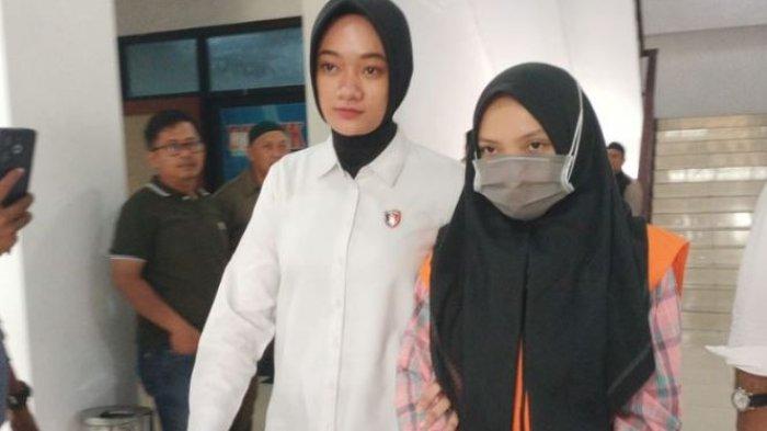 Karyawati Bank Jambi Kantor Cabang Kerinci, RS (26) digiring petugas saat akan melakukan konferensi pers di Mapolda Jambi, Senin (2/6/2025). RS ditetapkan sebagai tersangka pembobolan rekening nasabah hingga Rp7,1 miliar