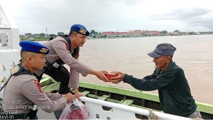 BAGI TAKJIL - Personel Ditpolairud Polda Jambi melaksanakan kegiatan pembagian takjil kepada masyarakat pesisir, nelayan, dan penambang ketek di wilayah Kota Jambi pada Senin, (10/03/2025)