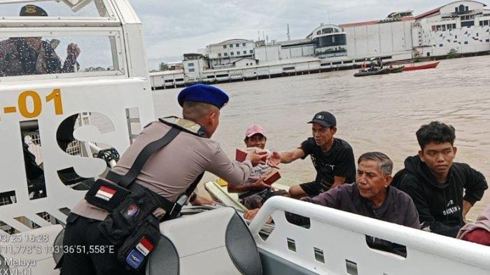 BAGI TAKJIL - Personel Ditpolairud Polda Jambi melaksanakan kegiatan pembagian takjil kepada masyarakat pesisir, nelayan, dan penambang ketek di wilayah Kota Jambi pada Senin, (10/03/2025)