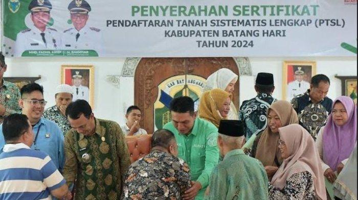 Bupati Batanghari Muhammad Fadhil Arief menyerahkan sertifikat Pendaftaran Tanah Sistematis Lengkap (PTSL) pada masyarakat di Kecamatan Batin XXIV.