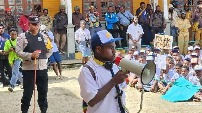 AKSI TOLAK MAKAN BERGIZI GRATIS - Ratusan pelajar di Kabupaten Dogiyai, Papua Tengah, Senin (17/2/2025), menggelar aksi unjuk rasa menolak program Makan Bergizi Gratis (MBG) yang dicanangkan oleh pemerintah pusat. Nampak Koordinator aksi, Ochep Youw, menyatakan pernyataan sikap kepada pemerintah pusat. (Tribun-Papua.com/Istimewa)