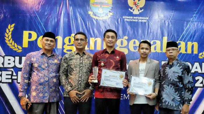 Pj Bupati Muaro Jambi Bachyuni Deliansyah dan Kadis Kominfo M Faisal Harahap foto bersama usai menerima penghargaan keterbukaan Informasi Publik