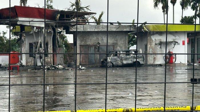 SPBU JELUTUNG TERBAKAR - Pascakejadian kebakaran SPBU Jelutung Kota Jambi pada Rabu (30/4/2025) pagi, garis polisi sudah dipasang di lokasi kejadian. Kerangka mobil terlihat di lokasi.