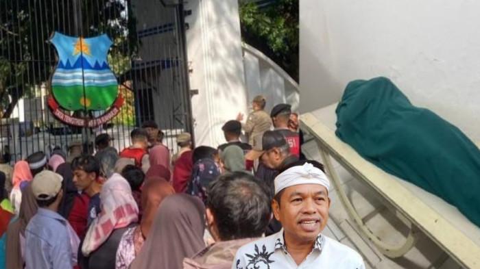 ANTRE MAKAN GRATIS - Warga mengantre di gerbang Pendopo Alun-Alun Garut, Jawa Barat,  menunggu gelaran makan gratis yang merupakan rangkaian kegiatan pernikahan Wakil Bupati Garut Putri Karlina dan Maula Akbar putra dari Gubernur Jawa Barat Dedi Mulyadi, Jumat (18/7/2025) siang. Tercata ada tiga orang meninggal dunia.