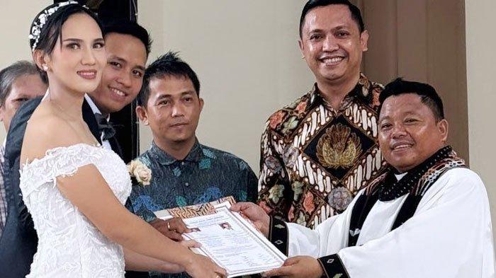 Pengantin ditemani Ronny dan istri menunjukkan akta pernikahan