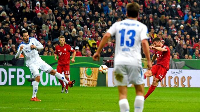 Pemain Bayern Muenchen, Xabi Alonso (merah, kanan) melepaskan tendangan voli ke gawang Darmstadt.