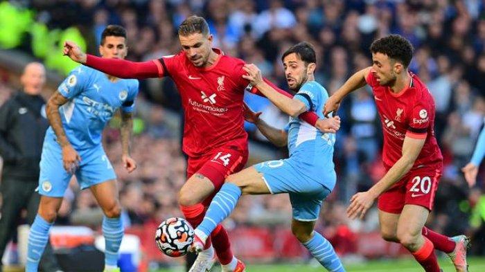 Gelandang Manchester City, Bernardo Silva, berupaya untuk menghentikan kapten Liverpool, Jordan Henderson, kala kedua tim bertemu di pekan ketujuh Liga Inggris, Minggu (3/10/2021). Duel dua tim di Anfield tersebut berakhir imbang 2-2.