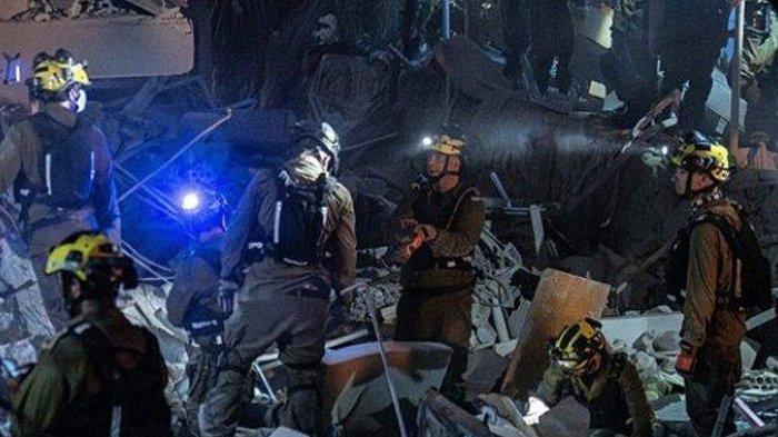 TERTIMBUN RERUNTUHAN - Para petugas penyelamat Israel mencari korban atas serangan Iran pada Sabtu (14/6/2025) malam hari di Israel tengah dan utara. Serangan Iran ke Israel picu gangguan mental dan krisis psikologis, lebih dari 4.700 panggilan masuk ke hotline kesehatan Israel sejak perang pecah.