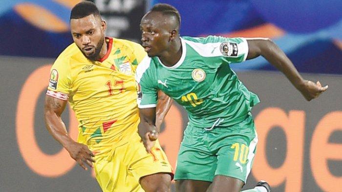 Pemain depan Senegal Sadio Mane ditandai oleh gelandang Benin Stephane Sessegnon selama pertandingan baru-baru ini di Kairo.