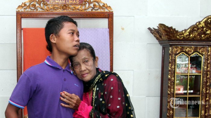 Slamet Riyadi (16) berfoto bersama istri barunya Rohaya (71) saat ditemui di Hotel Batiqa, Palembang, Selasa (11/7/2017). Slamet dan Rohaya merupakan pasang suami isteri yang perbedaan umurnya cukup jauh. TRIBUN SUMSEL/ABRIANSYAH LIBERTO