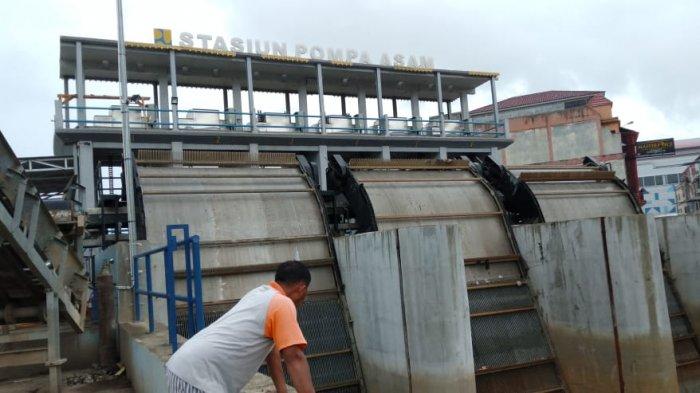 Terlihat Operator Stasiun Pompa Kawasan Sungai Asam, Anto, melihat kondisi kenaikan air.