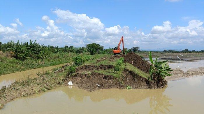 TANGGUL JEBOL - BPBD Kabupaten Grobogan bergerak cepat melakukan perbaikan tanggul di Sungai Renggong yang jebol dan mengakibatkan banjir, Minggu (18/5/2025).