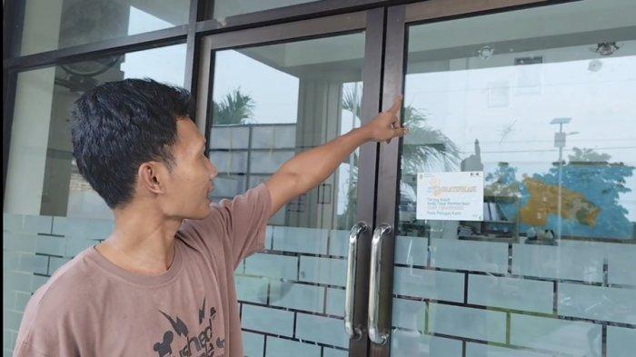 BEKAS TEMBAKAN - Eko, warga Desa Langse, Kecamatan Margorejo, Kabupaten Pati memperlihatkan cekungan bekas tembakan peluru senapan angin di pintu kaca balai desa setempat, Rabu (28/5/2025). Total ada enam titik bekas tembakan yang ditemukan, baik di dinding maupun pintu Kantor Desa Langse.
