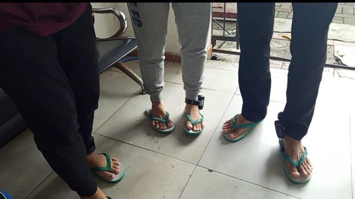 ALAT PENDETEKSI - Kaki para mahasiswa yang dipasang gelang kaki GPS di kantor Kejari Semarang, Kamis (19/6/2025). Kaki mereka dipasang alat pendeteksi sebagai syarat tahanan kota. 