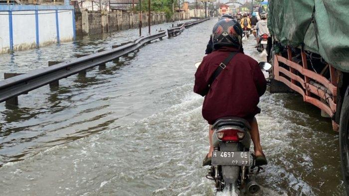 TERJANG BANJIR - Pengendara motor saat menerjang banjir rob di Kabupaten Demak. Berikut tips penting guna meminimalkan risiko kerusakan sekaligus menjaga performa motor tetap optimal selama musim rob.