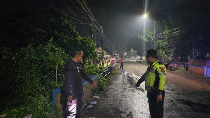 KECELAKAAN TUNGGAL: Polisi melakukan olah tempat kejadian perkara kecelakaan tunggal di Jalan Letjen Sutoyo Kelurahan Kebonsari Kecamatan Sumbersari Jember, Jawa Timur, Minggu (29/6/2025) malam. Pria ditemukan tewas di sungai. (TRIBUN JATIM/ISTIMEWA)