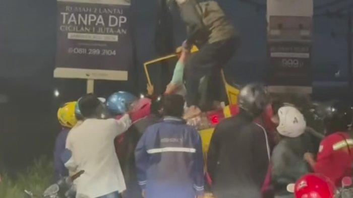 EVAKUASI KORBAN - Sejumlah warga dan pemotor mengevakuasi mobil angkutan kota yang terbalik di dekat exit Tol Kaliwungu Kendal, Senin (7/7/2025) malam. Mobil tersebut diduga berjalan terlalu ke kanan, kemudian terguling dan menimpa pemotor yang melintas di sisi kirinya.