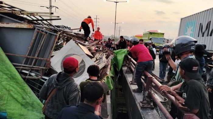 TERGULING - Truk bermuatan besi rosok terguling di Flyover Jalan Arteri Utara Yos Sudarso Semarang, Rabu (23/7/2025). Pemotor yang melintas dilaporkan tertimpa muatan truk yang mengalami kecelakaan itu.