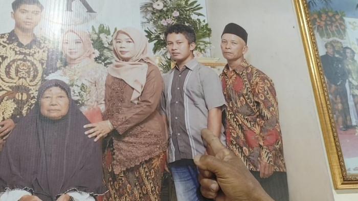 TUNJUKKAN FOTO - Sutikno, ayah mendiang Kukuh Riyanto (34), menunjukkan foto sang anak yang terpajang di dinding rumah mereka di Desa Beketel, Kecamatan Kayen, Pati, Selasa (29/7/2025). Kukuh adalah korban pembunuhan yang jasadnya ditemukan terikat tali di dalam jurang.
