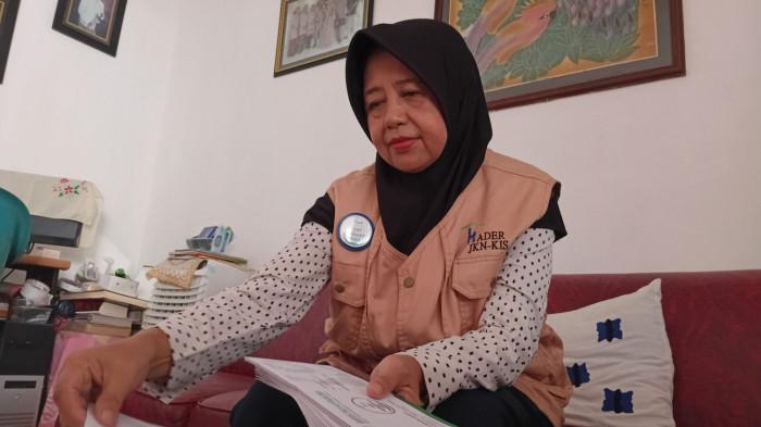 KADER JKN - Ernawati (62), warga Perumahan Gerbang Harapan Jalan Madukoro II RT IV RW VI, Desa Gondangmanis, Kecamatan Bae, Kabupaten Kudus sedang menyiapkan berkas sebelum menyambangi mitra binaan kader JKN, Kamis (31/7/2025). Kesibukannya saat ini diniatkan sebagai ibadah menjadi mitra pejuang sehat.