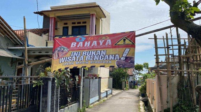 PERINGATAN - Banner besar yang dipasang di akses masuk Dukuh Krajan Desa Mandala Kecamatan Sirampog Kabupaten Brebes, Rabu (27/5). Banner tersebut menjadi imbauan akan bencana geologi landslide atau tanah bergerak. (TRIBUN JATENG/BUDI SUSANTO)