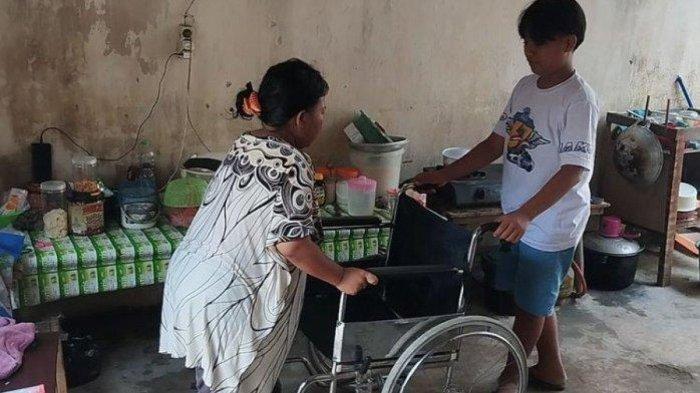 Adit saat menemani Sarmini, ibunya, yang tengah sakit stroke di rumahnya di Dusun Kuningan Desa Tiru Kidul, Kecamatan Gurah, Kabupaten Kediri, Jawa, Timur, Selasa (14/5/2024).