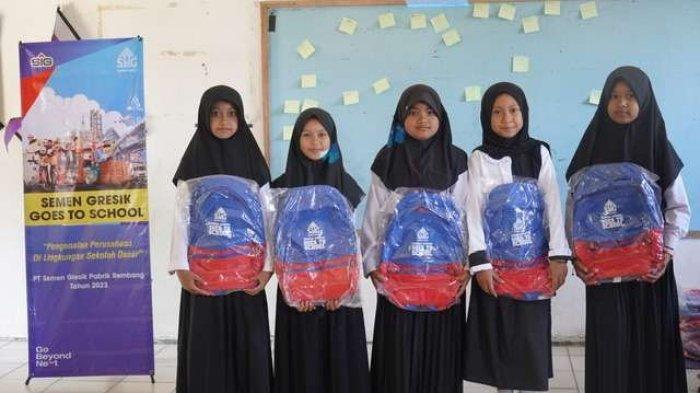 Anak – anak Sekolah Dasar menerima paket peralatan belajar berupa tas sekolah pada kegiatan program Semen Gresik Goes to School di SD N Timbrangan, Kecamatan Gunem, Rembang.