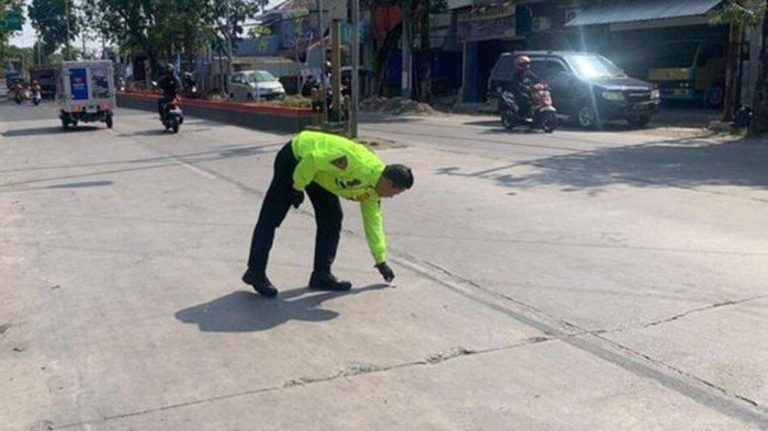 Anggota Satlantas Polres Grobogan melakukan olah TKP kecelakaan pemotor yang tewas menabrak tiang telepon dan pohon di Jalan Diponegoro, Purwodadi, Kabupaten Grobogan, Senin (18/9/2023).