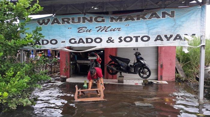 Seorang warga Kelurahan Trimulyo, Kecamatan Genuk, Kota Semarang memanfaatkan genangan air banjir untuk membersihkan perabotan, Minggu (17/3/2024).