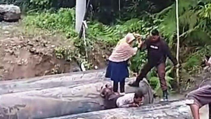 Polisi rela punggung diinjak demi jadi jembatan warga untuk menyebrangi sungai.