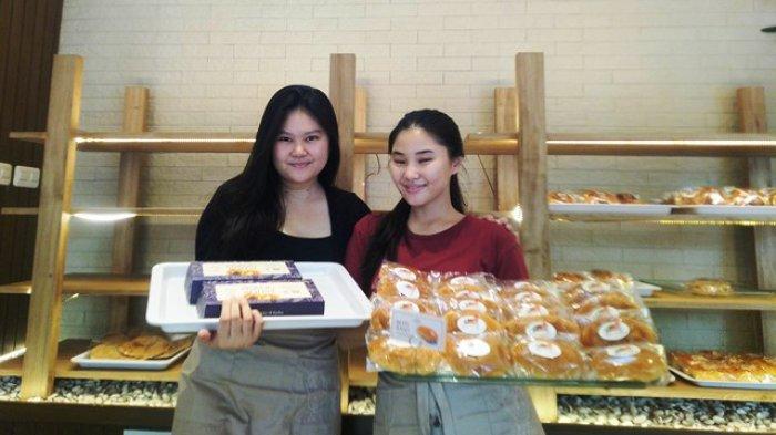 Cecilia Chandra (kiri) dan Chintia Chandra (kanan) menunjukkan produk roti best seller yang diproduksi Rumah Roti Kartini Kudus, Senin (22/4/2024).