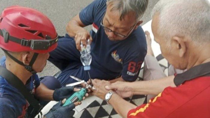 Pengantin pria bersama petugas Damkar setelah cincin berhasil dilepas