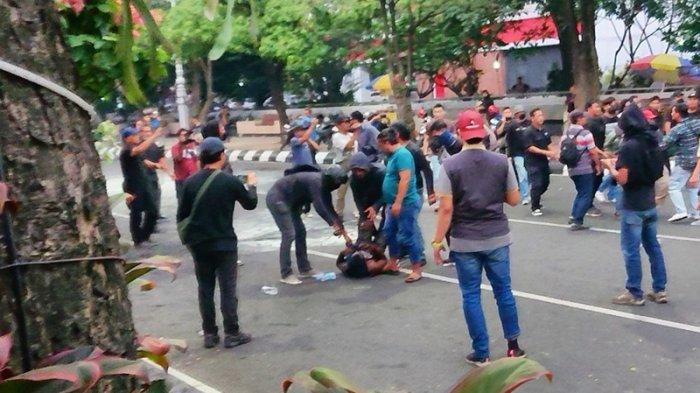 DITANGKAP - Satu di antara massa aksi ditangkap oleh beberapa petugas tanpa seragam resmi saat mengikuti May Day di Kantor Gubernur Jateng, Kamis (1/5/2025).