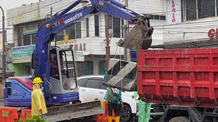 EVAKUASI MEDIAN JALAN - Para pekerja membongkar atau mengevakuasi median jalan beton menggunakan ekskavator dan memindahkannya ke bak truk di Jalan Jenderal Sudirman, Ambarawa, Kabupaten Semarang, Kamis (20/2/2025). Median jalan tersebut dibongkar agar nantinya jalan bisa diratakan dan diberlakukan sistem satu arah.
