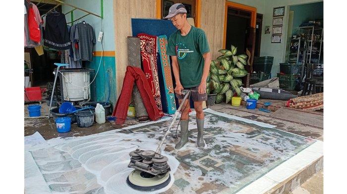 CUCI KARPET - Eko Susanto sedang mencuci karpet di tempat usahanya Bekti Laundry di Desa Garung Lor, RT 2 RW 2, Kecamatan Kaliwungu, Kabupaten Kudus, Rabu (26/3/2025). Permintaan jasa laundry meningkat dua kali lipat pada momentum Ramadan hingga menjelang Lebaran.