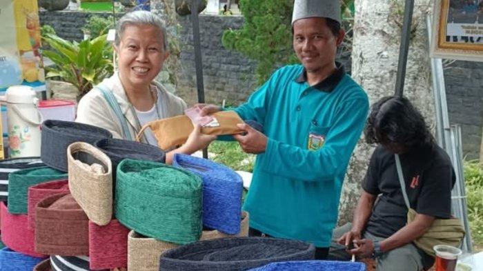 LAYANI PEMBELI- Faizin, produsen Peci Sobo asal Desa Sojokerto Kecamatan Leksono Wonosobo melayani pembeli produknya, Kamis (21/3/2025) 