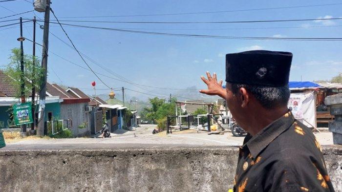 Guru kelas SDN 2 Plesungan, Rachmaddiyanta menunjukan kawasan TPA Putri Cempo yang masih diselimuti asap putih akibat terbakar pada Selasa (19/9/2023) siang.