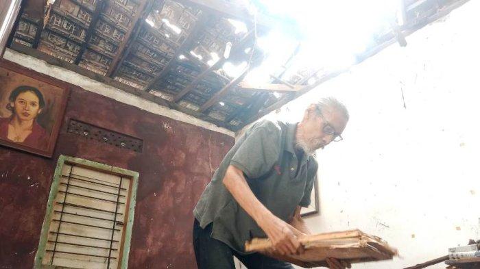 Joko Wahyono sedang membereskan puing-puing runtuhan atap di rumahnya di Randukuning, Kelurahan Pati Lor, Kecamatan pati, Kabupaten Pati, Selasa (6/2/2024).