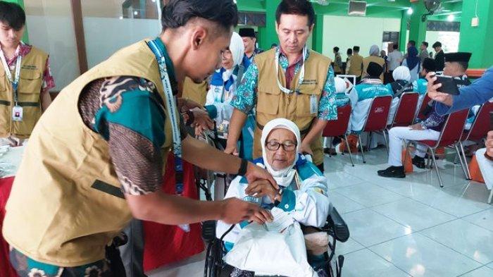 KEDATANGAN CALON HAJI - Petugas membantu lansia berjalan setelah keluar bus menuju Gedung Jeddah saat kedatangan Kloter 1 di Asrama Haji Donohudan Boyolali, Kamis (1/5/2025) pagi. Kloter 1 merupakan jemaah calon haji asal Kabupaten Purbalingga.