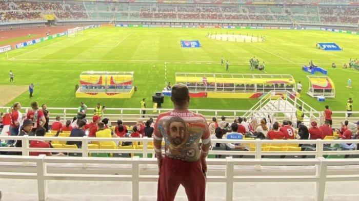 Katon, suporter Timnas Indonesia asal Temanggung, Jateng, mendukung aksi Timnas U17 Indonesia versus Panama dalam matchday kedua Grup A Piala Dunia U17 di Stadion GBT Surabaya, Senin (13/11/2023). 