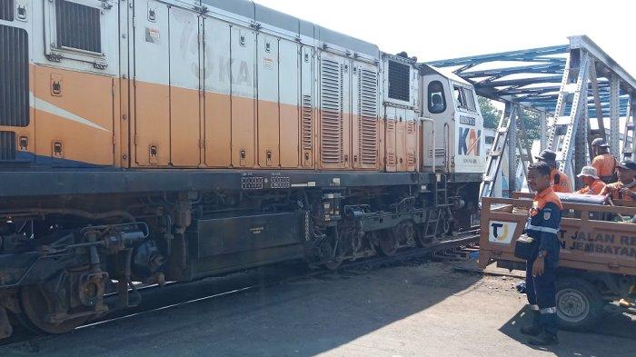 Kereta api melintas dengan kecepatan terbatas di jalur ganda perlintasan dengan palang pintu Madukoro Semarang, Rabu (19/7/2023)..