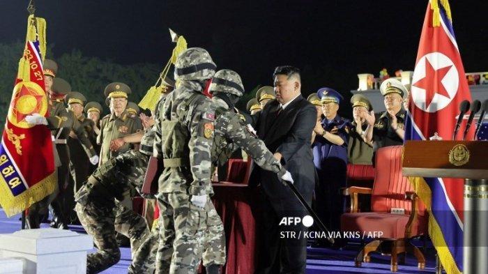 Gambar yang diambil pada tanggal 4 Agustus 2024 dan dirilis oleh Kantor Berita Pusat Korea (KCNA) resmi Korea Utara melalui KNS pada tanggal 5 Agustus menunjukkan pemimpin Korea Utara Kim Jong Un (tengah) menghadiri upacara penyerahan peluncur rudal balistik taktis tipe baru ke Korea Utara.