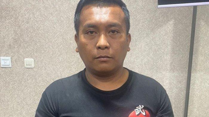 Michael Gomgom, sopir taksi online yang melakukan penculikan hingga pemerasan ke penumpang wanita sebesar Rp100 juta setelah ditangkap dan ditetapkan sebagai tersangka.