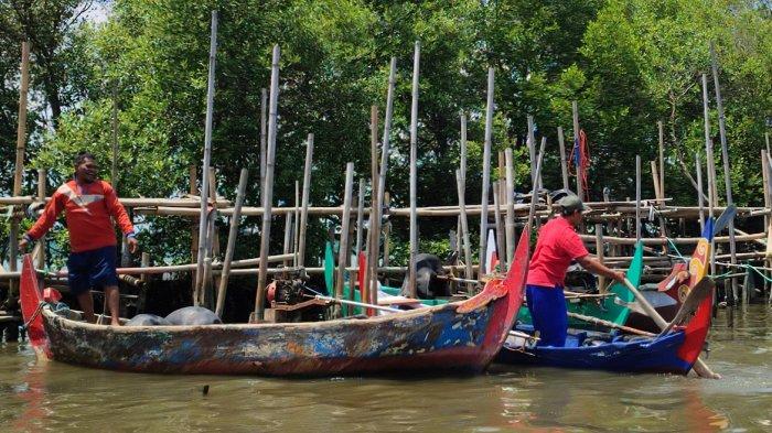 Nelayan yang menambatkan perahunya di Kali Sringin hendak menuju ke laut melewati sebuah barat pabrik di sisi barat Kawasan Industri Terboyo, Genuk, Kota Semarang. Mereka kondisinya kian terdesak saat proyek TTLSD mulai dijalankan, Jumat (2/2/2024).