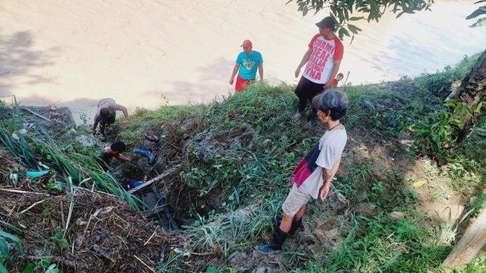 PEMBERSIHAN PINTU AIR - Warga melakukan pembersihan pintu air di bantaran sungai dekat perumahan Dinar Indah agar sampah tak menutupi saluran pembuangan air/TRIBUNJATENG.COM/ REZANDA AKBAR D.